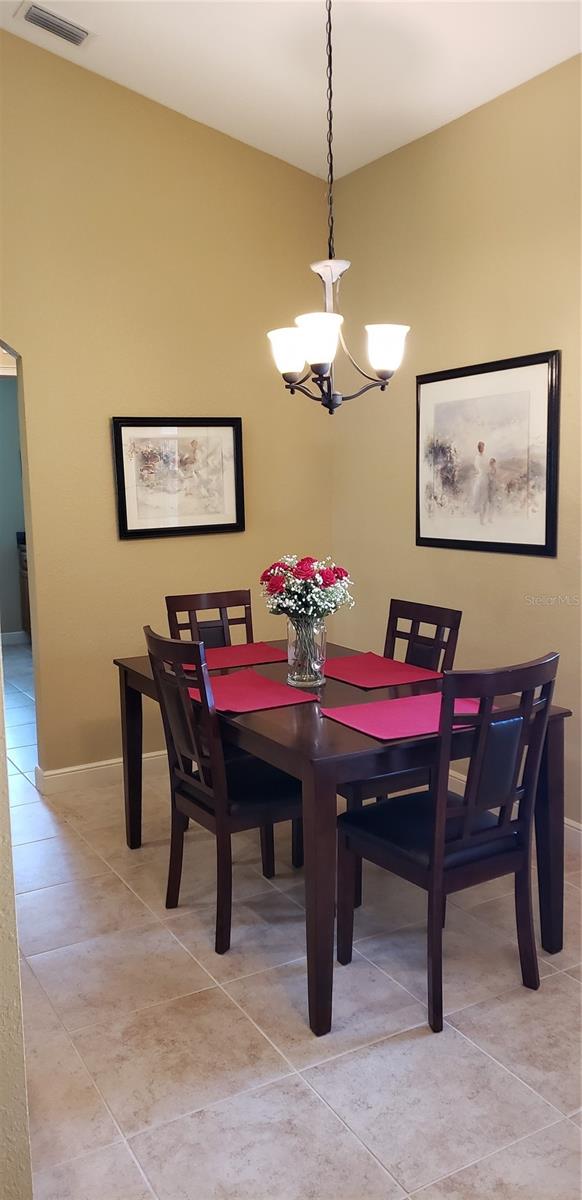 dining area featuring a chandelier and light tile patterned floors