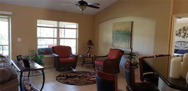 living area with ceiling fan, lofted ceiling, and light tile patterned floors