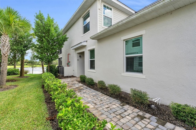 exterior space with a lawn and central AC unit