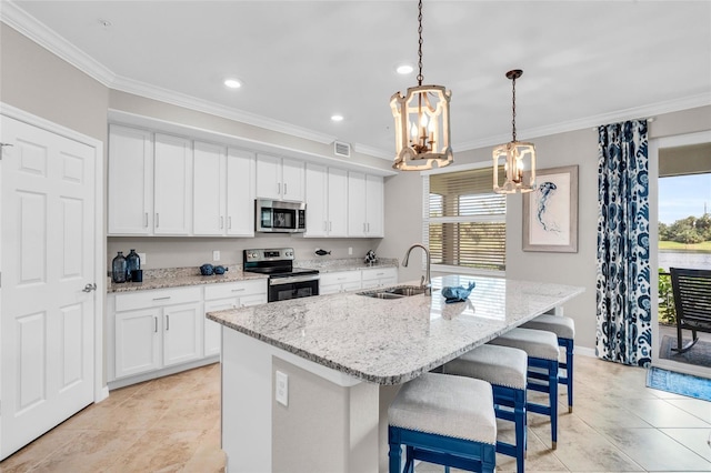 kitchen featuring sink, appliances with stainless steel finishes, a healthy amount of sunlight, and an island with sink