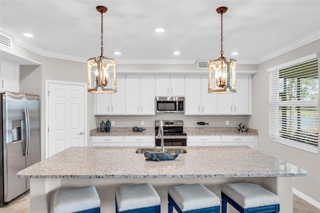 kitchen featuring a kitchen island with sink, stainless steel appliances, sink, and pendant lighting