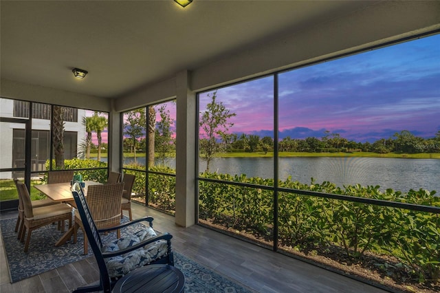 unfurnished sunroom featuring a water view