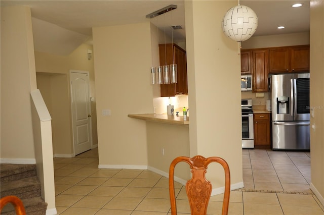 kitchen with pendant lighting, stainless steel appliances, and light tile patterned floors