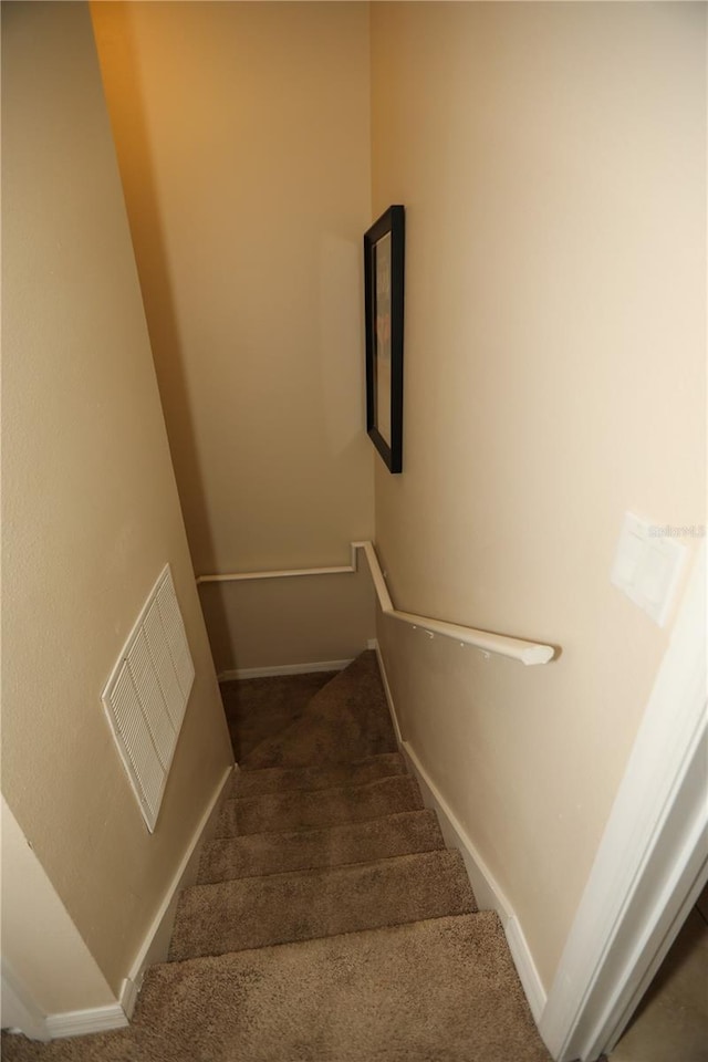 stairway featuring carpet flooring