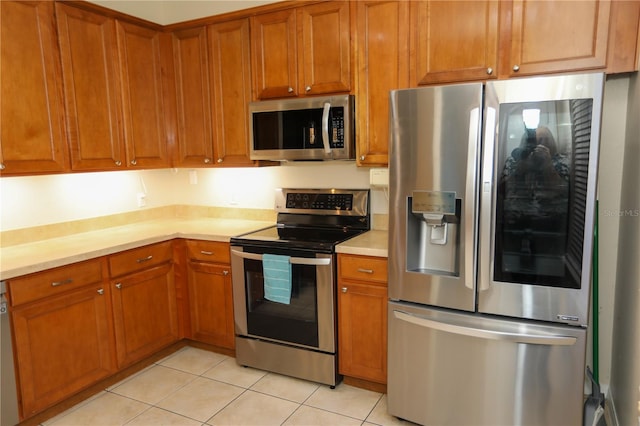 kitchen with appliances with stainless steel finishes and light tile patterned floors