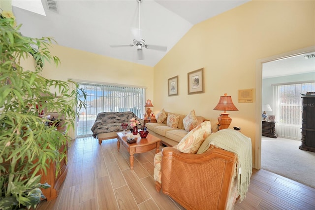 living room with light wood-type flooring, vaulted ceiling, and ceiling fan