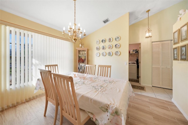 dining space with washer / clothes dryer, a notable chandelier, lofted ceiling, and light wood-type flooring