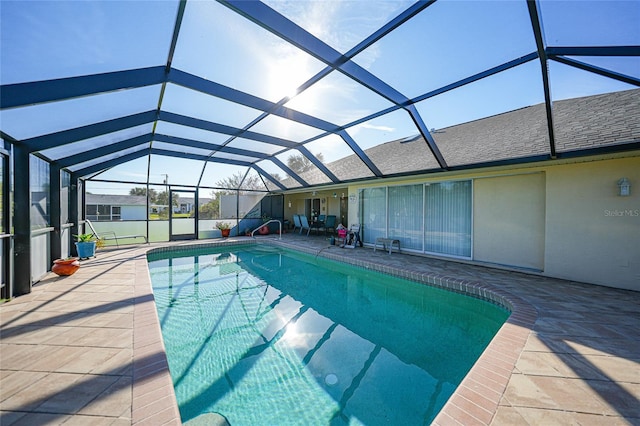 view of pool with a patio and glass enclosure