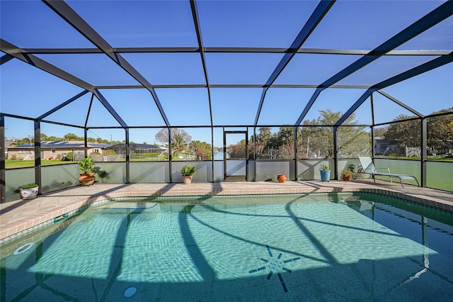 view of pool with glass enclosure and a patio area