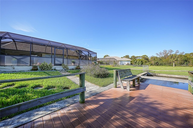 deck with a lanai, a dock, a lawn, and a water view