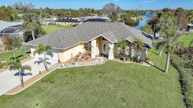 view of front of home featuring a front yard, a water view, and a garage