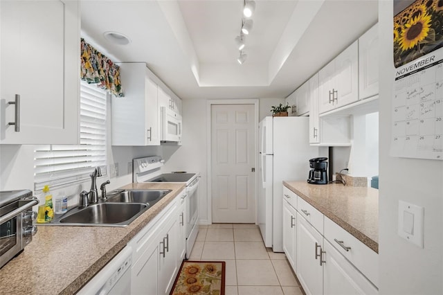 kitchen with sink, light tile patterned floors, white appliances, a tray ceiling, and white cabinets