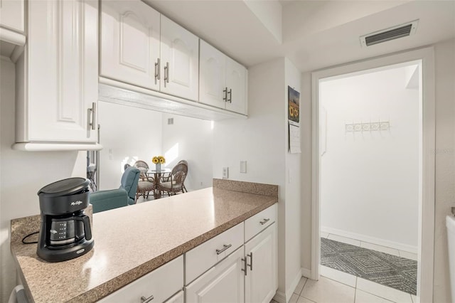 kitchen with white cabinetry and light tile patterned flooring