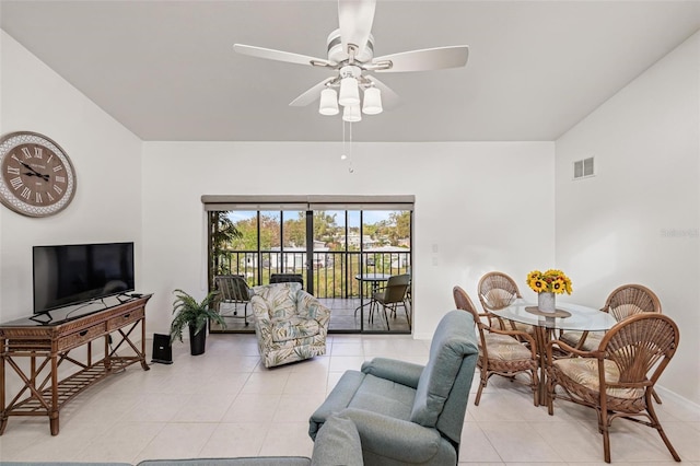 tiled living room featuring ceiling fan and vaulted ceiling