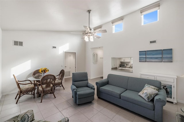 living room with ceiling fan, high vaulted ceiling, and light tile patterned flooring