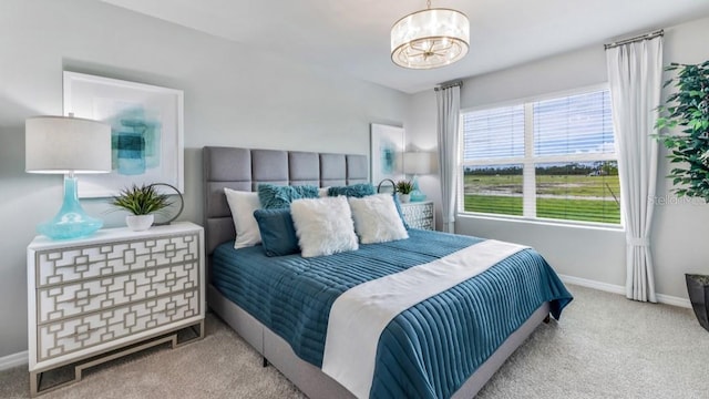 carpeted bedroom with a notable chandelier