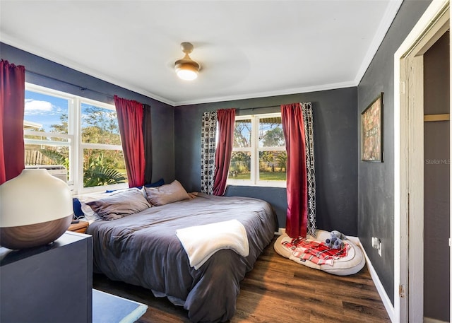 bedroom featuring dark hardwood / wood-style flooring, multiple windows, and ceiling fan