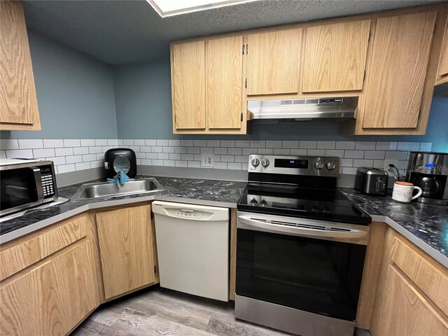 kitchen with decorative backsplash, light brown cabinets, light hardwood / wood-style flooring, sink, and appliances with stainless steel finishes