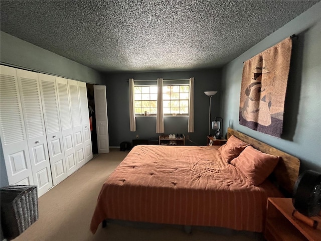 bedroom with a textured ceiling, carpet flooring, and a closet