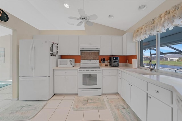 kitchen with white appliances, light tile patterned flooring, ceiling fan, lofted ceiling, and white cabinets