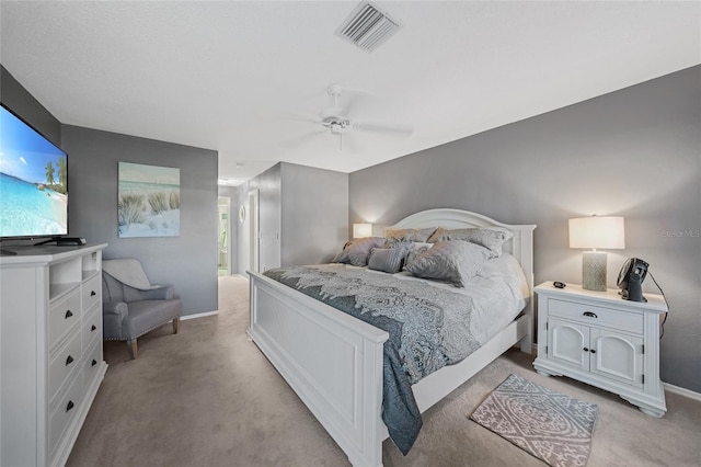 carpeted bedroom with ceiling fan and ensuite bath