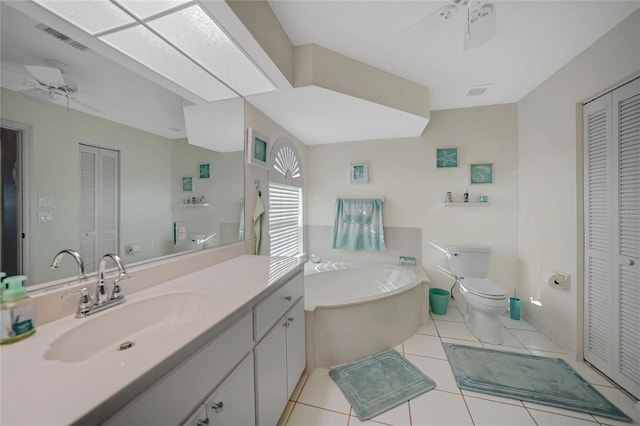 bathroom with tile patterned floors, a tub to relax in, toilet, vanity, and ceiling fan