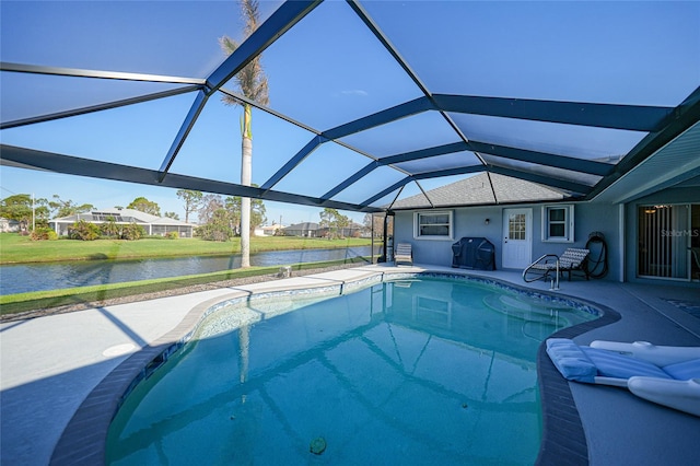 view of swimming pool featuring a patio area, area for grilling, a water view, and glass enclosure