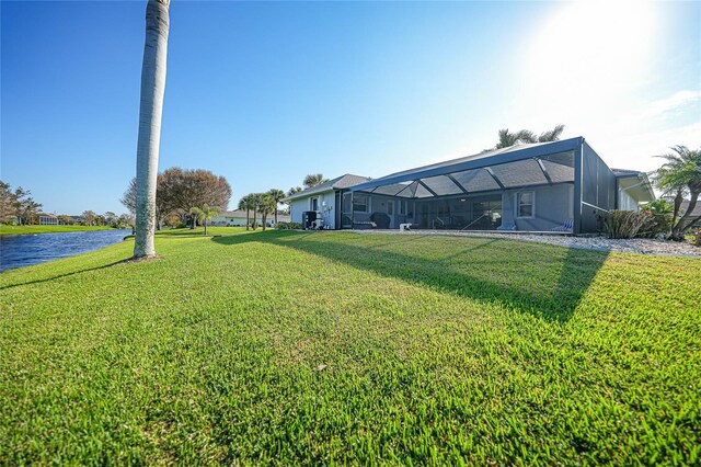 view of yard featuring a water view and glass enclosure