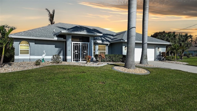 view of front of home with a lawn and a garage