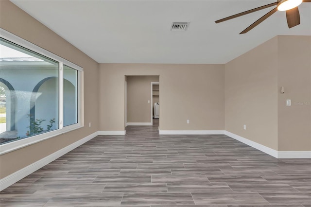 empty room featuring visible vents, ceiling fan, baseboards, and wood finished floors