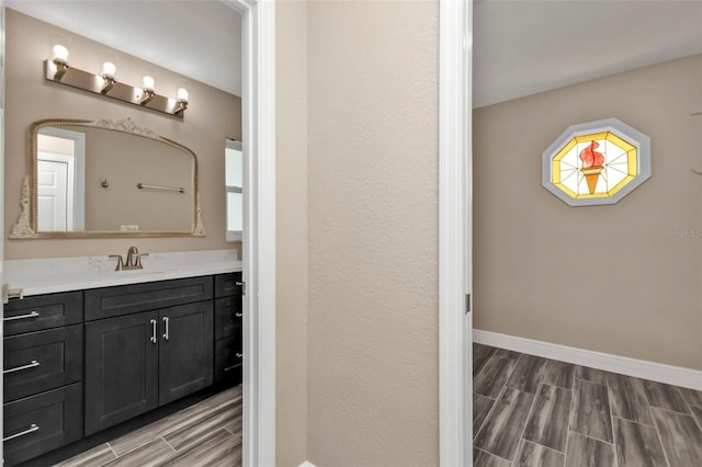 bathroom featuring vanity, baseboards, and wood tiled floor