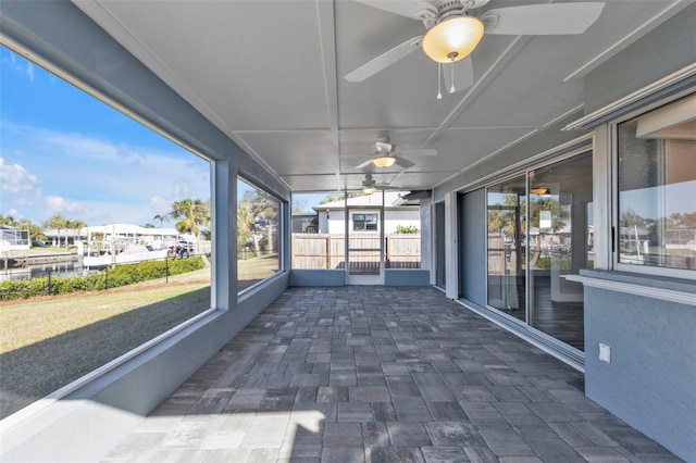 unfurnished sunroom with ceiling fan