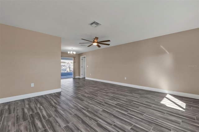 spare room with wood finish floors, ceiling fan with notable chandelier, visible vents, and baseboards