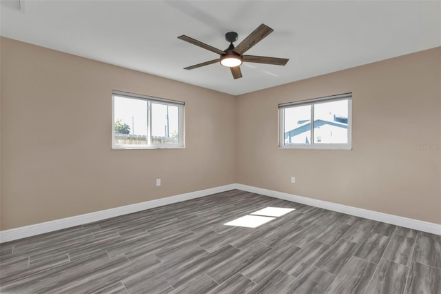 unfurnished room with baseboards, plenty of natural light, a ceiling fan, and wood tiled floor