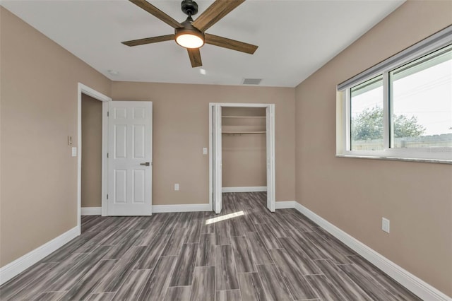 unfurnished bedroom with a closet, visible vents, wood finish floors, and baseboards