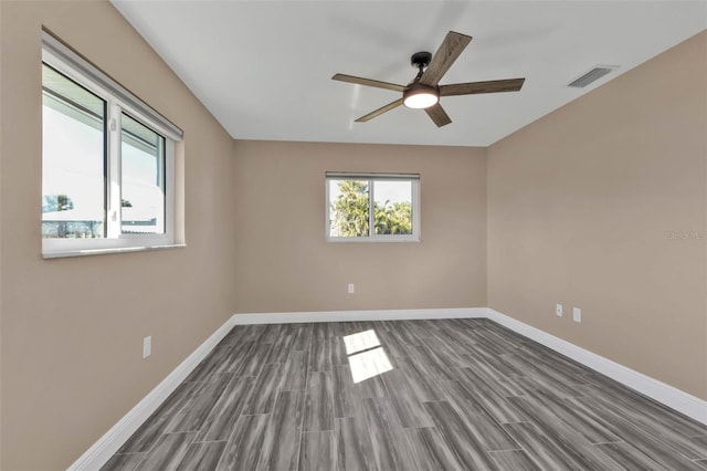 unfurnished room featuring wood finish floors, visible vents, baseboards, and a ceiling fan