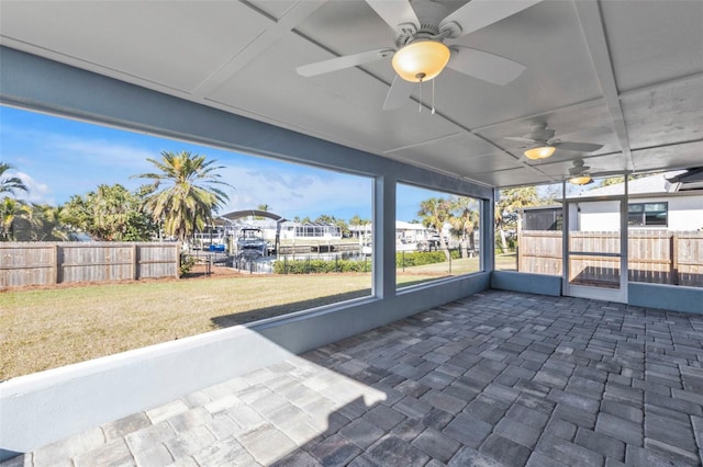 unfurnished sunroom featuring a ceiling fan