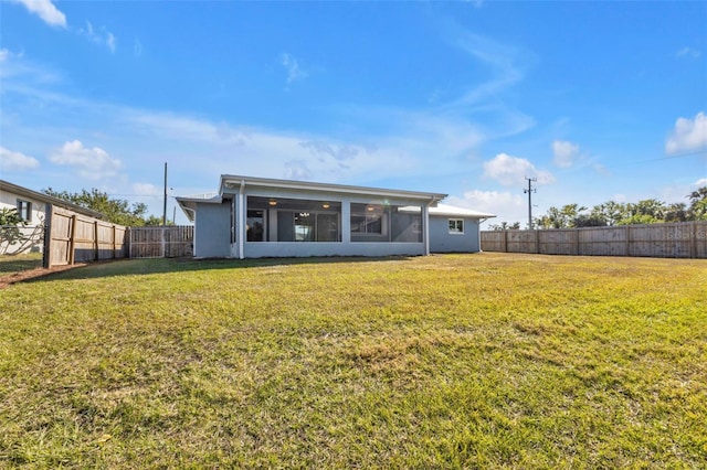 back of house with a lawn, a fenced backyard, and a sunroom