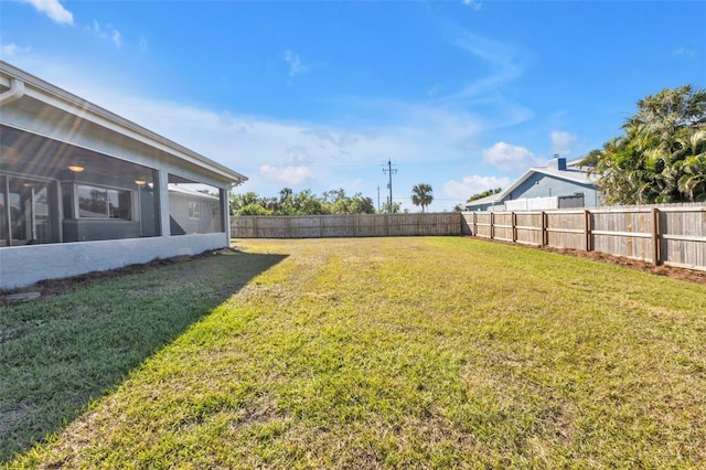 view of yard with a fenced backyard and a sunroom