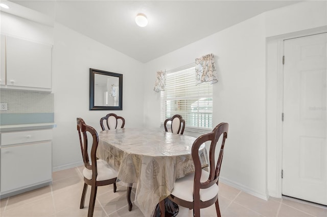 tiled dining space featuring lofted ceiling