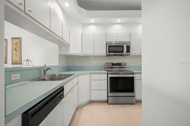 kitchen featuring tasteful backsplash, light tile patterned flooring, appliances with stainless steel finishes, sink, and white cabinets