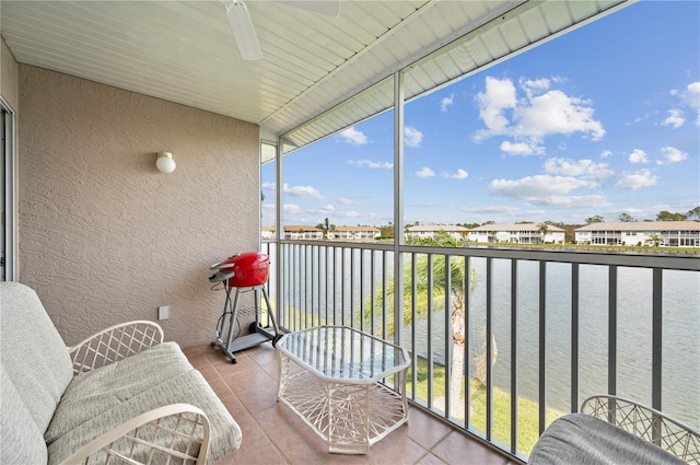 balcony featuring a water view and ceiling fan