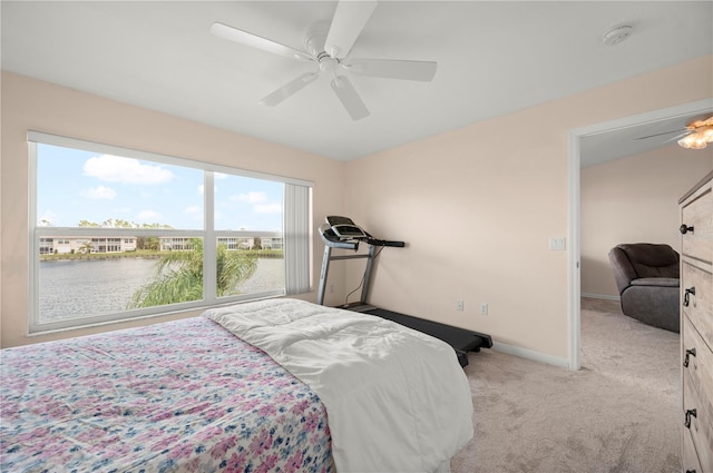 bedroom featuring ceiling fan, a water view, and light colored carpet