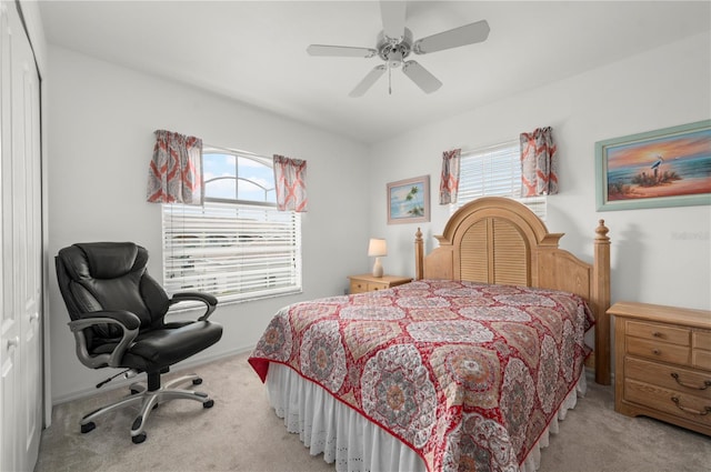 carpeted bedroom featuring ceiling fan, multiple windows, and a closet