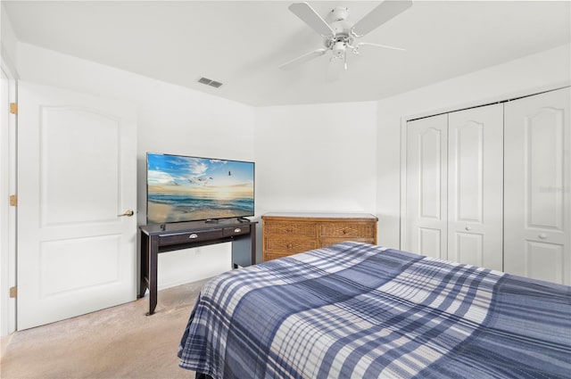 bedroom featuring ceiling fan, a closet, and light colored carpet