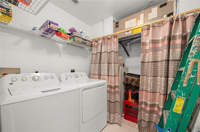 washroom featuring washing machine and clothes dryer and light tile patterned floors