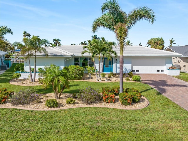 ranch-style house with a garage, stucco siding, decorative driveway, and a front yard