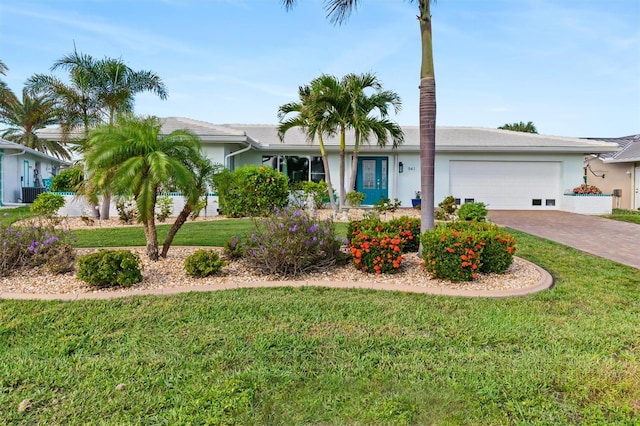 single story home with a garage, a front yard, decorative driveway, and stucco siding