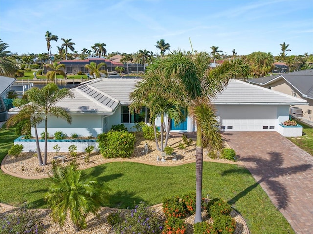 view of front of house featuring a garage, stucco siding, decorative driveway, and a front yard