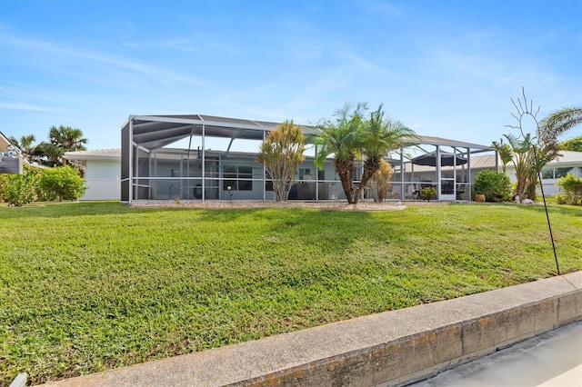 rear view of house featuring a lawn and a lanai